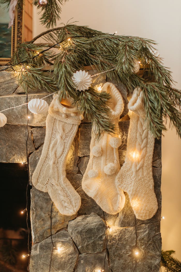 services-02 Warm Christmas stockings hanging on a decorated fireplace with lights.