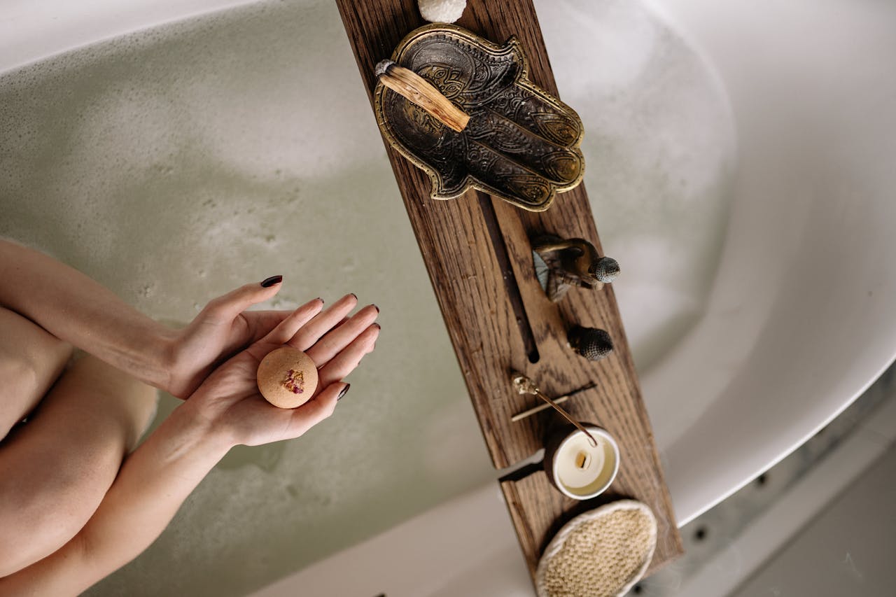 gallery-4 A soothing bath scene featuring a bath bomb and tray with relaxing essentials.