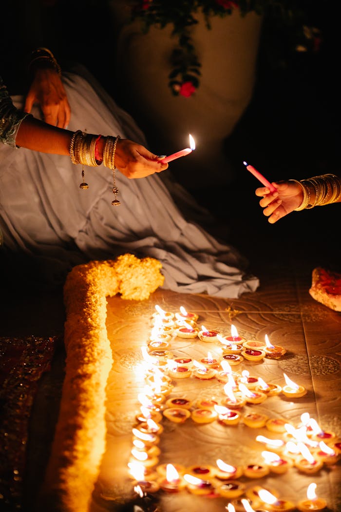 services-01 Two women lighting diyas during a festive celebration, symbolizing hope and unity.